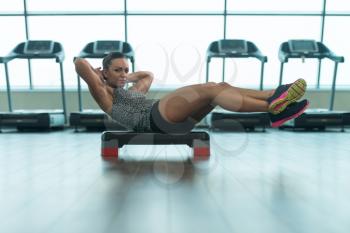 Young Woman Athlete Doing Abs Exercise On Stepper As Part Of Bodybuilding Training
