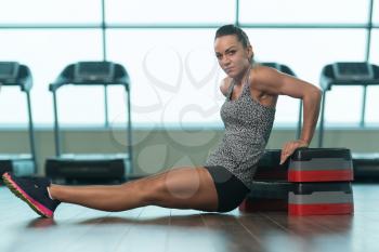 Young Woman Athlete Doing Triceps Exercise On Stepper As Part Of Bodybuilding Training