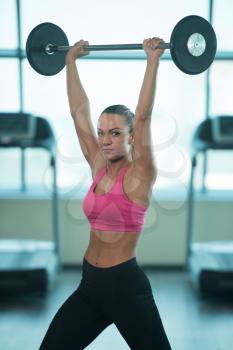 Young Woman Working Out Shoulders With Barbell In A Gym - Shoulder Exercise