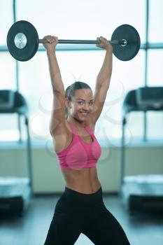 Young Woman Working Out Shoulders With Barbell In A Gym - Shoulder Exercise