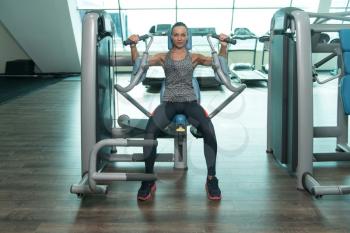 Young Woman Exercising Chest On Machine In The Gym And Flexing Muscles - Muscular Athletic Bodybuilder Fitness Model Exercise In Fitness Center