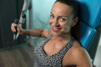 Portrait Of A Young Physically Fit Woman Exercising Chest On Machine - Muscular Athletic Bodybuilder Fitness Model Exercise In A Gym