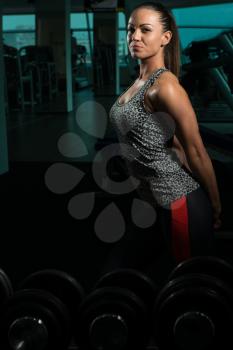 Young Woman Standing Strong In The Gym And Flexing Muscles - Muscular Athletic Bodybuilder Fitness Model Posing After Exercises