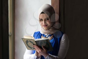 Young Muslim Woman Is Reading The Koran In The Mosque