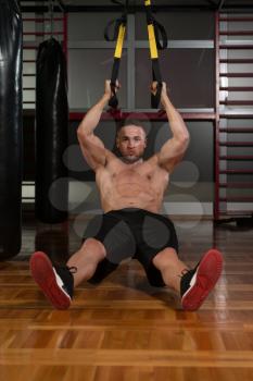 Attractive Man Does Crossfit Push Ups With Trx Fitness Straps In The Gym's Studio