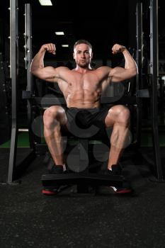 Portrait Of A Young Physically Fit Man Performing Biceps Pose - Muscular Athletic Bodybuilder Fitness Model Posing After Exercises
