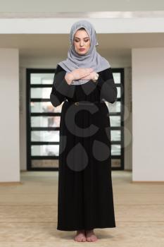 Young Muslim Woman Making Traditional Prayer To God While Wearing A Traditional Hijab And Dress