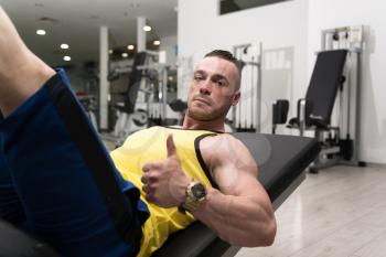 Young Man Using The Leg Press Machine At A Health Club In Gym