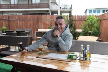 Portrait Of Happy Young Man Drinking Coffee Outdoor At Restaurant