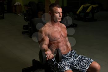 Young Man Working Out Biceps In A Dark Gym - Dumbbell Concentration Curls