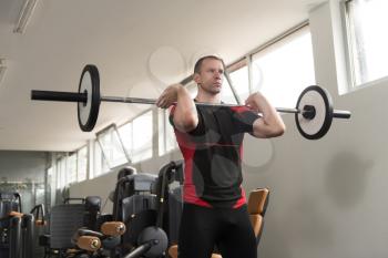 Good Looking And Attractive Man Performing Barbell Squats - One Of The Best Bodybuilding Exercise For Legs