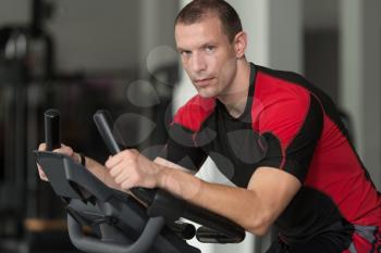 Fitness Man Exercising On Bike In A Modern Fitness Center