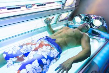 Young Muscular Man At Solarium In Beauty Salon