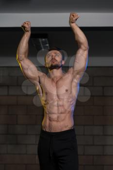 Handsome Man Standing Strong In The Gym And Flexing Muscles - Muscular Athletic Bodybuilder Fitness Model Posing After Exercises