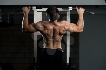 Handsome Man Athlete Doing Pull Ups - Chin-Ups In The Gym