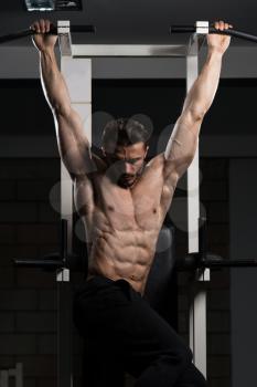 Handsome Man Performing Hanging Leg Raises Exercise - One Of The Most Effective Ab Exercises
