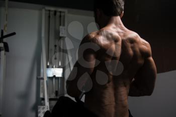 Handsome Bodybuilder Doing Heavy Weight Exercise For Back On Machine