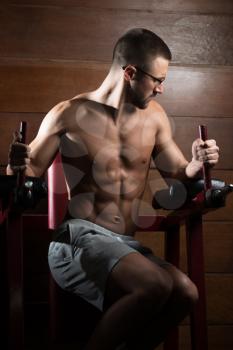 Handsome Man Wearing Glasses And Performing Hanging Leg Raises Exercise - One Of The Most Effective Ab Exercises