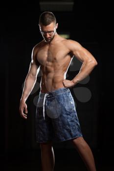 Portrait Of A Young Physically Fit Nerd Man Showing His Well Trained Body - Muscular Athletic Bodybuilder Fitness Model Posing After Exercises