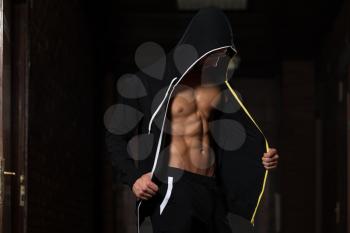 Portrait Of A Young Physically Fit Nerd Man Showing His Well Trained Body In Sports Clothing - Muscular Athletic Bodybuilder Fitness Model Posing After Exercises