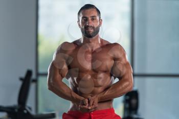 Portrait Of A Young Physically Fit Hispanic Man Showing His Well Trained Abdominal Muscles - Muscular Athletic Bodybuilder Fitness Model Posing After Exercises