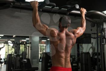 Young Man Athlete Doing Pull Ups - Chin-Ups In The Gym