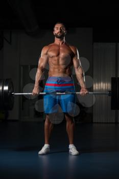 Latin Bodybuilder Doing Heavy Weight Exercise For Back With Barbell In Modern Gym