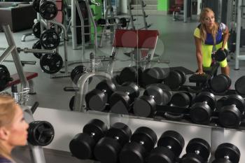 Mature Fitness Woman Working Out Back In Fitness Center
