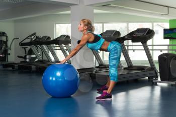 Mature Woman Exercising On Ball In The Gym And Flexing Muscles - Muscular Athletic Bodybuilder Fitness Model