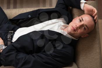 Handsome Young Man in Suit and Tie Sleeping or Resting in Sofa