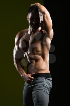 Healthy Man Standing Strong In The Gym And Flexing Muscles - Muscular Athletic Bodybuilder Fitness Model Posing After Exercises