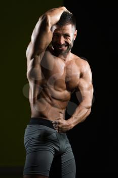 Handsome Man Standing Strong In The Gym And Flexing Muscles - Muscular Athletic Bodybuilder Fitness Model Posing After Exercises