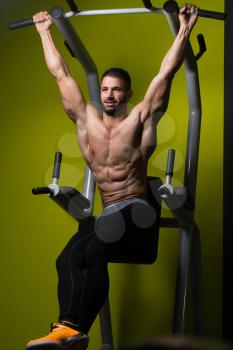 Muscular Man Performing Hanging Leg Raises Exercise - One Of The Most Effective Ab Exercises