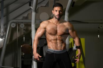 Handsome Man Standing Strong In The Gym And Flexing Muscles - Muscular Athletic Bodybuilder Fitness Model Posing After Exercises
