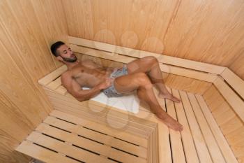 Happy Good Looking And Attractive Young Man With Muscular Body Relaxing In Hot Sauna