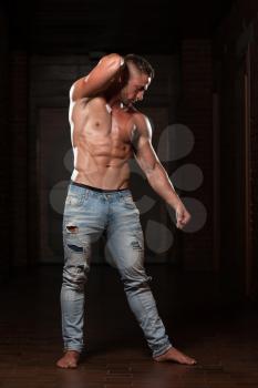 Handsome Young Man In Jeans Standing Strong In The Gym And Flexing Muscles - Muscular Athletic Bodybuilder Fitness Model Posing After Exercises