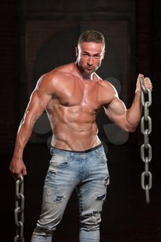 Healthy Young Bodybuilder Exercising Biceps With Chains