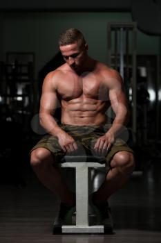 Resting Time - Confident Muscled Young Man Resting In Healthy Club Gym After Exercising