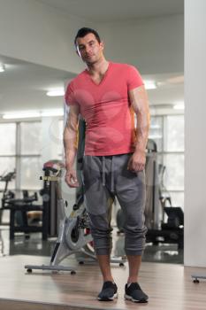 Healthy Young Man in Pink T-shirt Standing Strong and Flexing Muscles - Muscular Athletic Bodybuilder Fitness Model Posing After Exercises