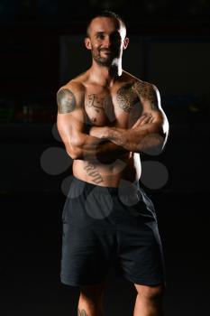 Handsome Young Man Standing Strong In The Gym And Flexing Muscles - Muscular Athletic Bodybuilder Fitness Model Posing After Exercises