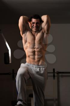 Young Man Standing Strong In The Gym And Flexing Muscles - Muscular Athletic Bodybuilder Fitness Model Posing After Exercises