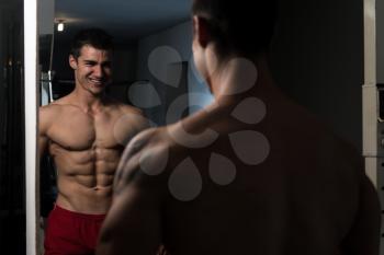 Portrait Of A Young Physically Fit Man Showing His Well Trained Abdominal Muscle - Muscular Athletic Bodybuilder Fitness Model Posing After Exercises