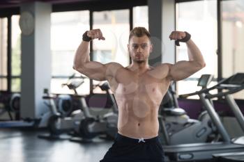 Handsome Man Standing Strong In A Modern Gym And Flexing Muscles - Muscular Athletic Bodybuilder Fitness Model Posing After Exercises