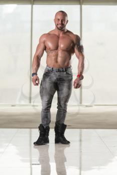 Handsome Young Man Standing Strong In Pants And Flexing Muscles - Muscular Athletic Bodybuilder Fitness Model Posing After Exercises