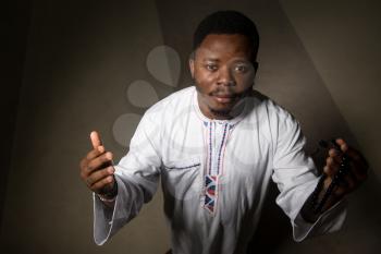 African Muslim Man Making Traditional Prayer To God While Wearing A Traditional Cap Dishdasha