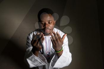 African Muslim Man Making Traditional Prayer To God While Wearing A Traditional Cap Dishdasha