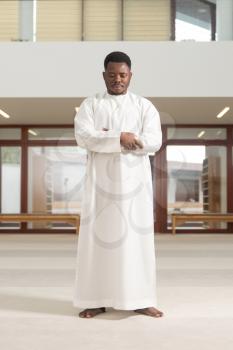 African Muslim Man Making Traditional Prayer To God While Wearing A Traditional Cap Dishdasha