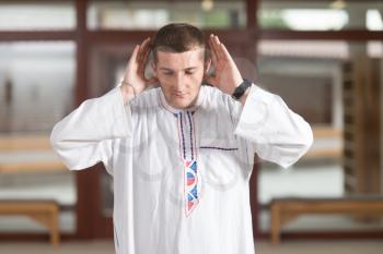 Portrait Of A Caucasian Muslim Man Making Traditional Prayer To God While Wearing A Traditional Cap Dishdasha