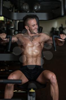Young Strong Man In The Gym And Exercising Chest On Machine - Muscular Athletic Bodybuilder Fitness Model Exercise