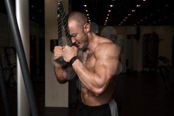 Handsome Muscular Fitness Bodybuilder Doing Heavy Weight Exercise For Triceps On Machine In The Gym